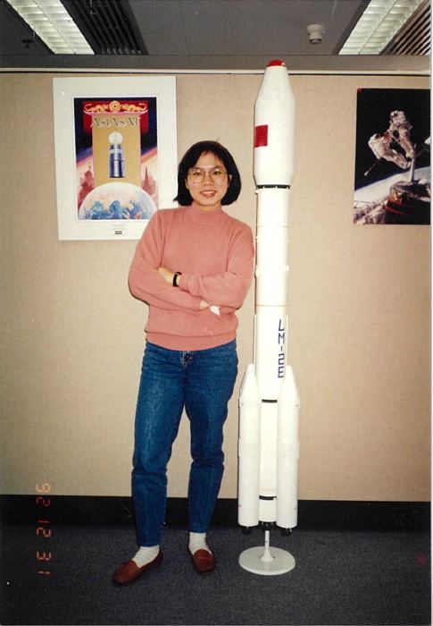 Pictures on the wall behind Betty: (left) A poster featuring AsiaSat 1’s Hughes HS-376 satellite model; (right) The astronauts retrieving the unused satellite Westar VI back to earth, which later became AsiaSat 1.  Next to Betty was the rocket model for launching AsiaSat 2 in 1995